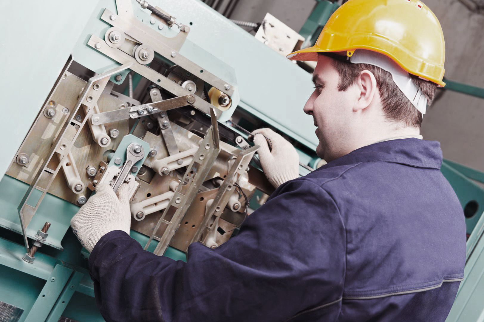 Handwerker zieht an Maschine eine Schraube nach