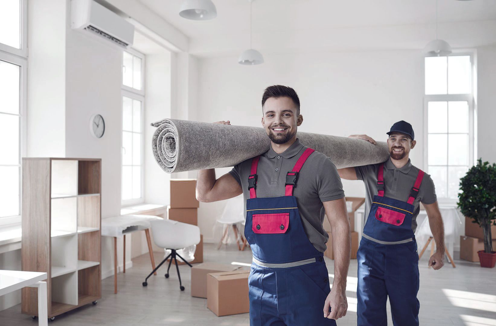 Zwei Männer tragen einen Teppich